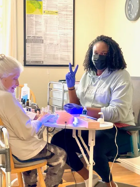 Nurse doing a manicure on elderly lady